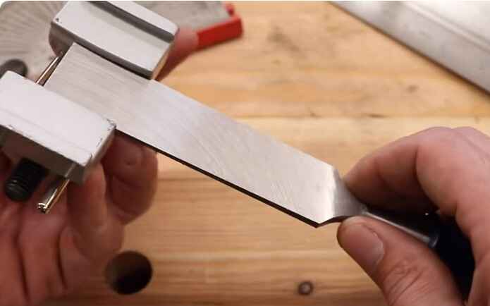 Why is it important to use a honing guide when sharpening chisels